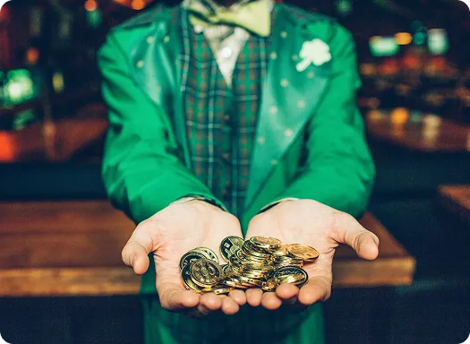 A man in a green suit is holding a handful of coins, showcasing his wealth and style.